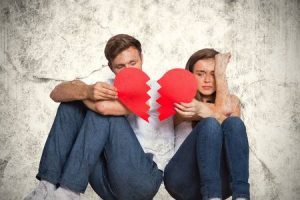 38515503-young-couple-holding-broken-heart-against-grey-background
